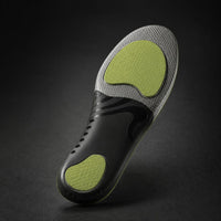 SOLVIX ArchCore padel insole, underside view showing the green MDDR shock pads and grey arch shell