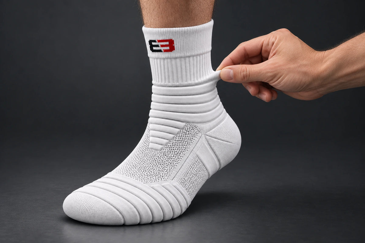 Fingers pinching the thick padded ankle band of the sock
